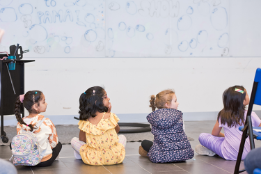 Children sitting in front of a white board