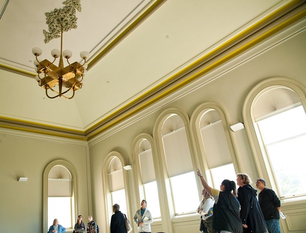 People touring PAMA while looking at a chandelier.