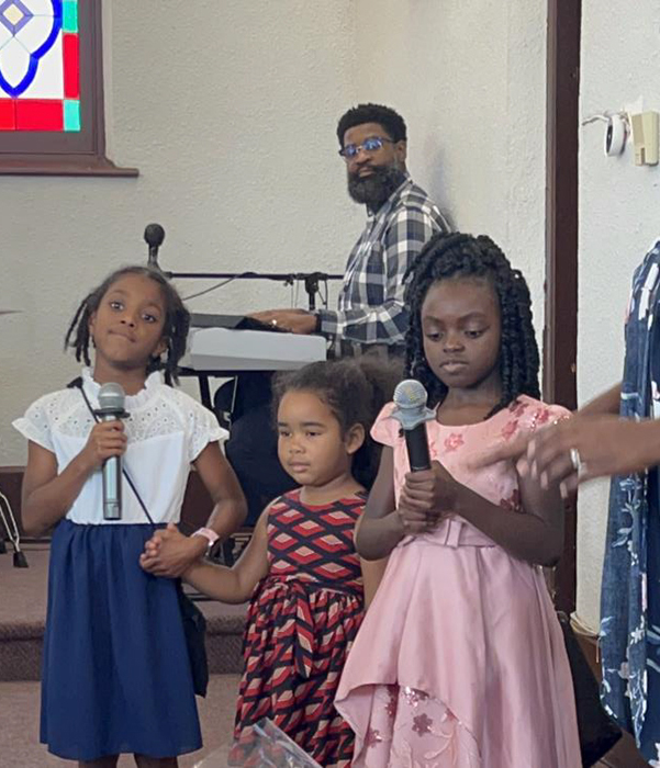 young girls singing in worship at church