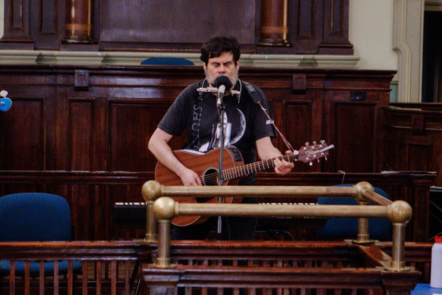 Glenn McFarlane performing with his guitar